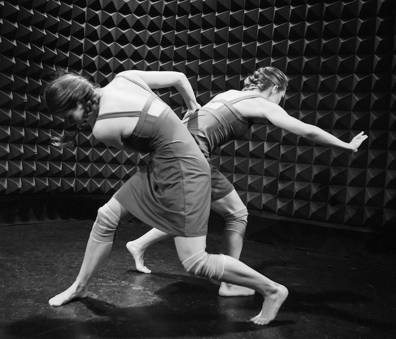 Dancers Kristen Bell and Callie Ritter are entwined in a crouch position in Jennifer Edward's